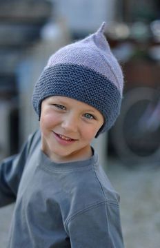 a young boy wearing a knitted hat and smiling