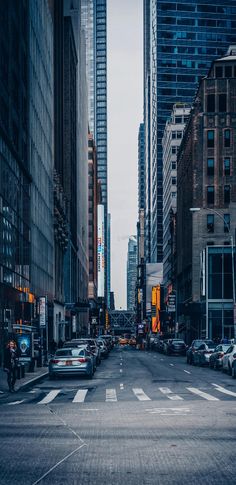 a city street filled with lots of tall buildings and traffic lights on either side of the road