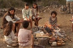 a group of people sitting around a campfire