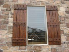 a window with wooden shutters on a stone wall