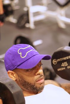 a man with a purple hat is lifting a barbell