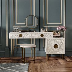 a white vanity with two stools in front of it and a mirror on the wall