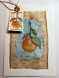 a piece of paper with an orange on it next to a rubber stamp and string