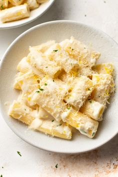 two white bowls filled with pasta and cheese