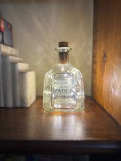 a glass bottle sitting on top of a wooden shelf