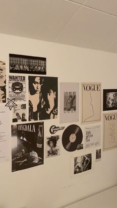 a wall covered in posters and records on it's sidewall, with one person standing next to the wall