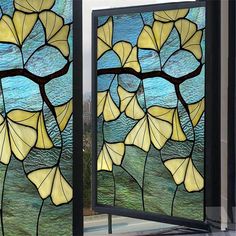 two stained glass panels with yellow flowers on them and blue water in the back ground