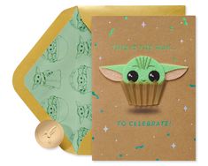 a card with an image of a baby yoda holding a cupcake on it