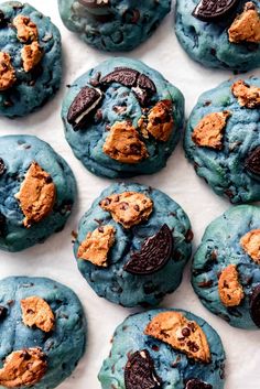 chocolate chip cookies with blue icing and oreo chips on top, ready to be eaten