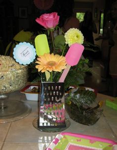 flowers in a vase sitting on top of a table next to plates and utensils