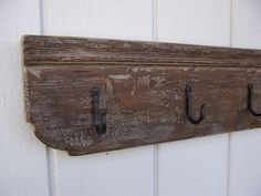 an old wooden coat rack with two hooks on it's side, hanging from the wall