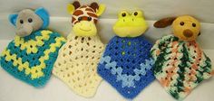 four stuffed animals are lined up on a white surface with crocheted afghans