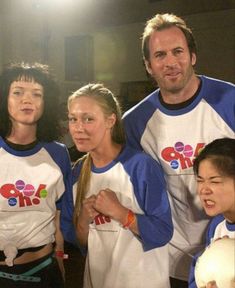 a group of people standing next to each other in blue and white shirts with words on them