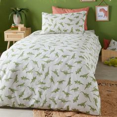 a green and white bed with dinosaurs on it