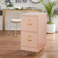 a white filing cabinet sitting on top of a hard wood floor next to a chair