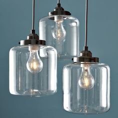 three clear glass pendant lights hanging from the ceiling