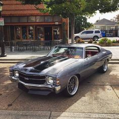 an old muscle car parked on the street