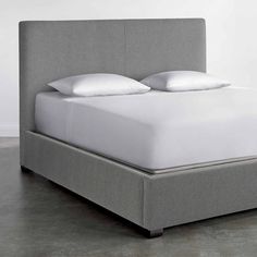 an upholstered bed frame with white pillows