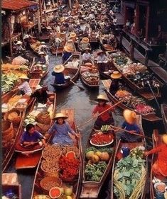 many boats are filled with people and vegetables