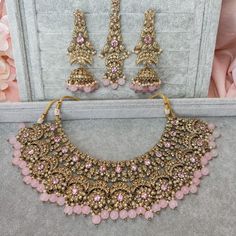 Beautifully flexible Antique Gold intricate necklace set scattered with dazzling golden crystals and light pink bead detailing Comes with matching long jhumka earrings (approx 3 inch length x 1.5 inch width) and matching tikka ( pendant part 2 inch length x 1.5 inch width)  Ready to ship as seen with gift box! Gold And Pink Jewelry Set, Pink Bridal Jewelry Sets, Pink Desi Jewelry, Pink Jwellary, Long Jhumka Earrings, Dream Reception, Brown Stuff, Kundan Jhumka