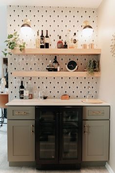 a kitchen area with cabinets and shelves filled with bottles, wine glasses and other items