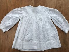 Adorable white lacy embroidered smock top with ruched sleeves. Sadly a couple of marks, as pictured, but would probably bleach out. W = 30cm; L = 42cm.  I am selling a large collection of beautiful vintage children's clothes - please check my other listings and message me with any questions or for postage offers for a bulk buy! White Long Sleeve Tops For Baptism, Long Sleeve Eyelet Tops For Daywear, Spring Long Sleeve Tops For Baptism, Spring Baptism Long Sleeve Tops, White Broderie Anglaise Lace Top For Spring, White Smocked Long Sleeve Blouse, White Smocked Blouse With Puff Sleeves, White Lace Top With Broderie Anglaise, White Long Sleeve Smocked Blouse