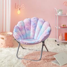 a pink and blue shell chair sitting on top of a white rug in a room