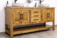 a bathroom vanity with two sinks and wooden cabinet