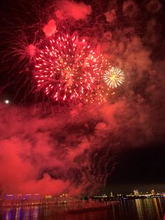 fireworks are lit up in the night sky over water