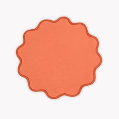 an orange place mat on a white surface with a circle shape in the middle and bottom