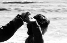 two people are touching each other on the beach