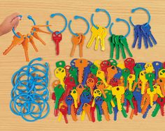 a bunch of keys that are on a table with some people holding them in their hands