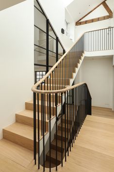 a wooden staircase with black railing and handrail