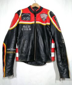 a black leather jacket with red, yellow and white stripes on the sleeves is hanging up