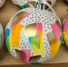 painted ornaments are sitting in a cardboard box