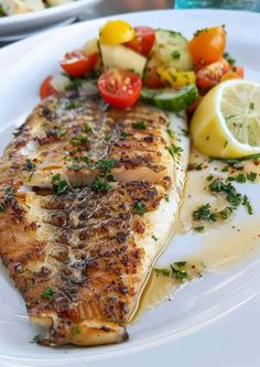 a white plate topped with fish and vegetables