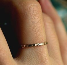 a woman's hand with a gold ring on it