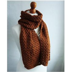 a brown crocheted scarf hanging on a mannequin