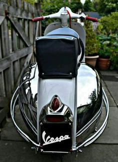 the back end of a motorcycle parked in front of a wooden fence