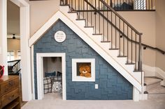 there is a dog house with a teddy bear in the door and stairs to the second floor