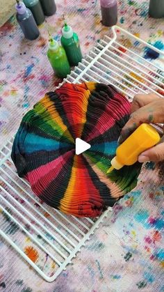 a person is painting a colorful object on a table