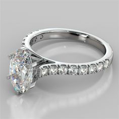 a white gold engagement ring with a princess cut diamond and side stones on the band