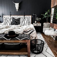 a bedroom with black walls and white rugs on the floor, including a bed