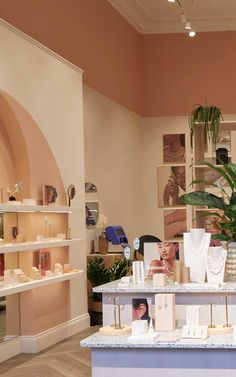 a room filled with vases and jewelry on display in front of a wall full of shelves