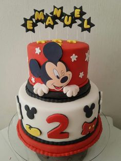 a mickey mouse birthday cake with the number 2 on top and two candles in the middle