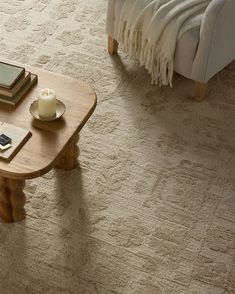 a coffee table sitting on top of a carpeted floor next to a couch and chair