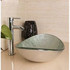 a bowl shaped sink sitting on top of a counter next to a faucet