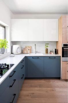 a kitchen with blue cabinets and white counter tops