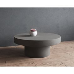 a round coffee table with a flower in a vase on it's center piece