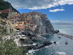 a village on the edge of a cliff next to the ocean